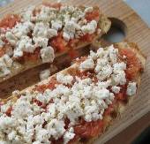 Riganatha: Grilled bread topped with tomatoes, feta cheese, and oregano